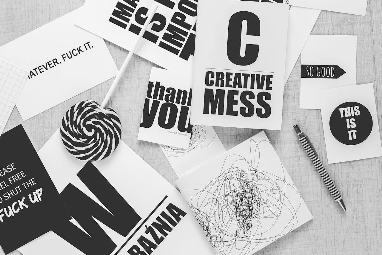 Monochrome desk scene with creative typography, candies, and a striped pen.